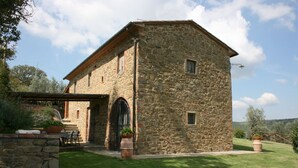 A stone building with a covered patio, a door, and a small window.