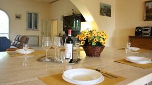 A dining table set with wine glasses, plates, and a basket of sunflowers. - Poggio Falcone (Castiglione del Lago)