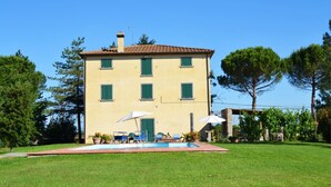 A two-story building with a swimming pool, outdoor seating, and a garden. - Villa Cantagallo (Cortona)