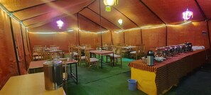 A tented dining area with tables and chairs, a buffet counter, and a trash bin. - TIH P3 Camp - Pangong (Leh)