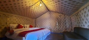 Una habitación con una cama, una silla y un papel tapiz estampado.