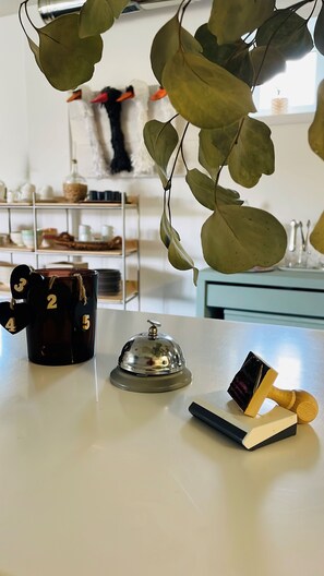 Una scrivania con una tazza di caffè, un libro, un francobollo e una pianta decorativa.