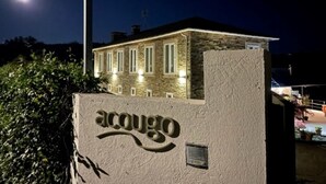 Un edificio in pietra con finestre illuminate e un cartello che recita "acougo" di notte.