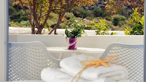 A white chair and table with a potted plant in the center. - Flora's Houses Mykonos (Mykonos)