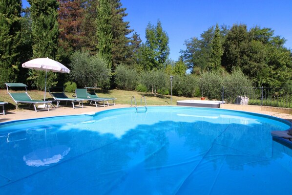 Alberca al aire libre por temporada y sombrillas en la alberca
