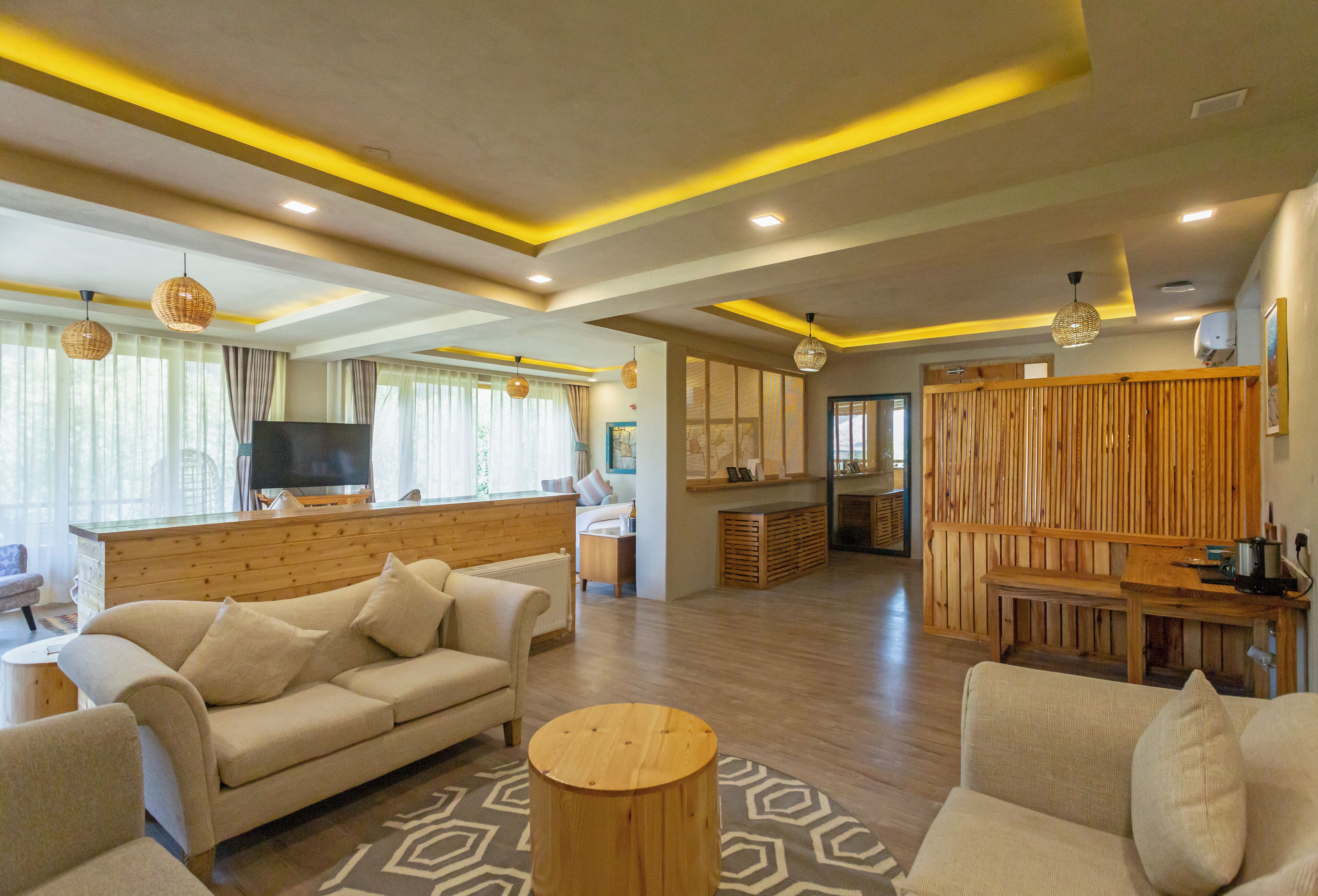 A spacious living area with a sofa, a round wooden coffee table, and a television.