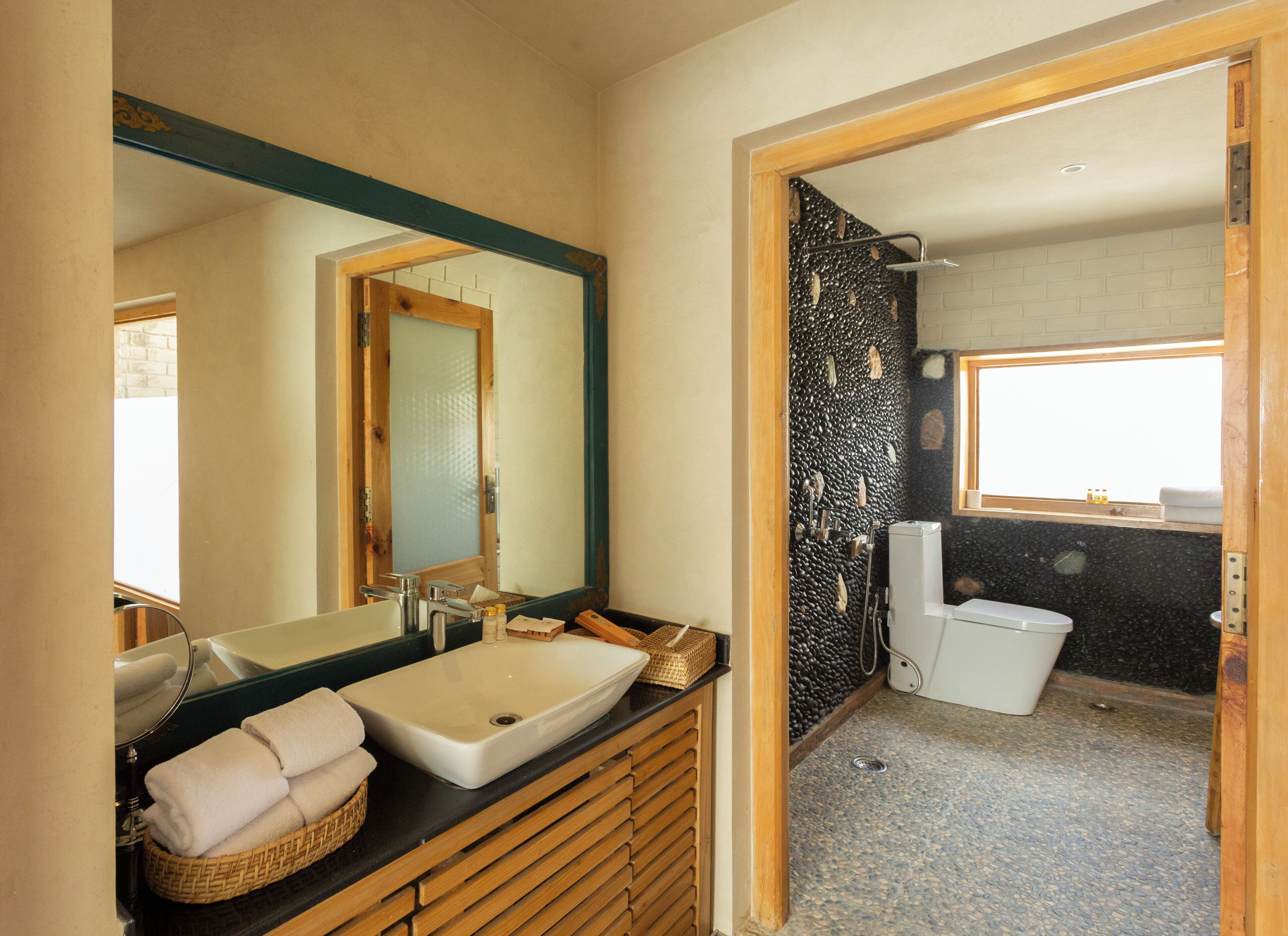 A bathroom with a large mirror, a sink, and a shower area.