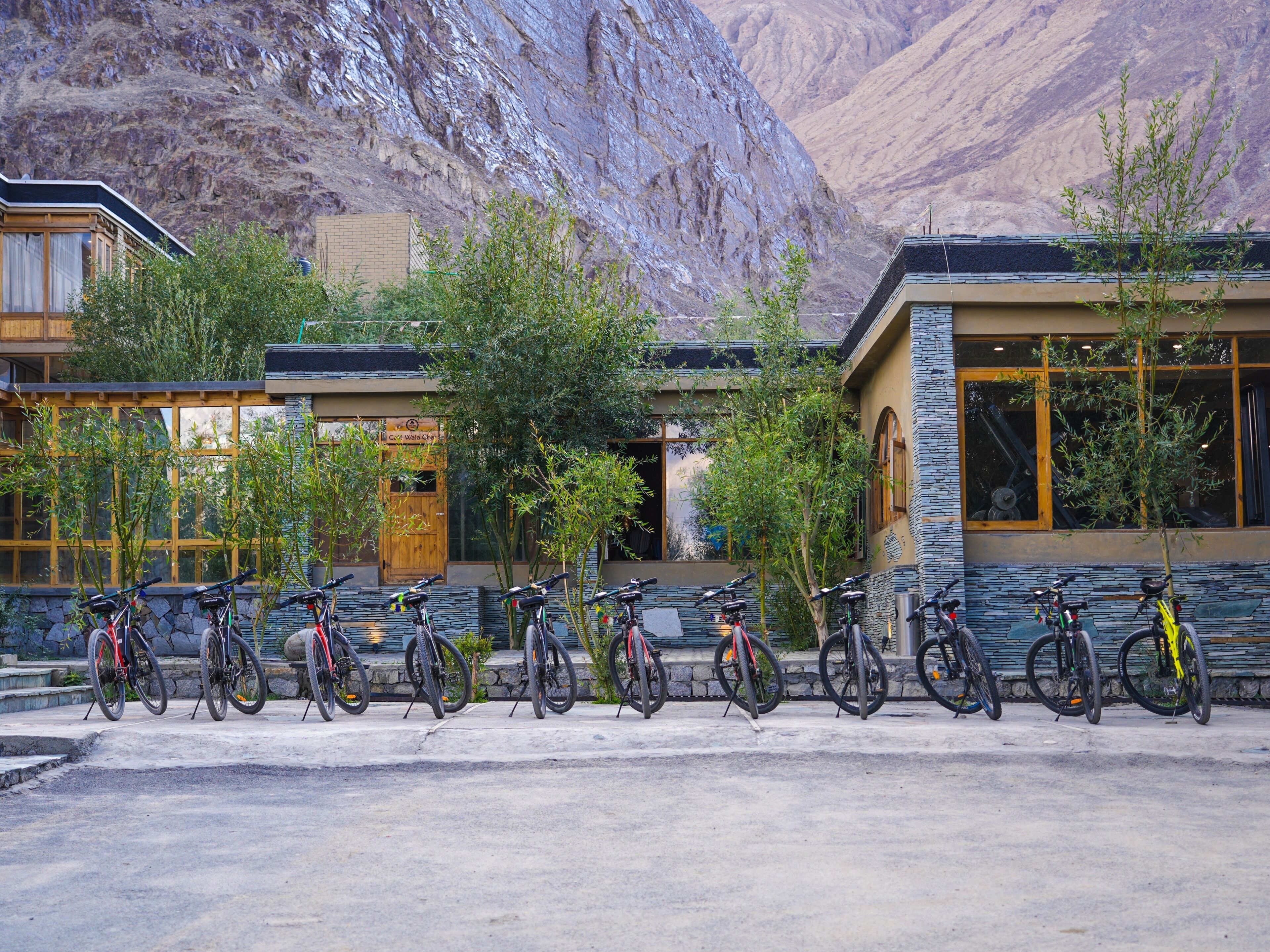 A building with a stone facade and large windows, surrounded by a row of bicycles.