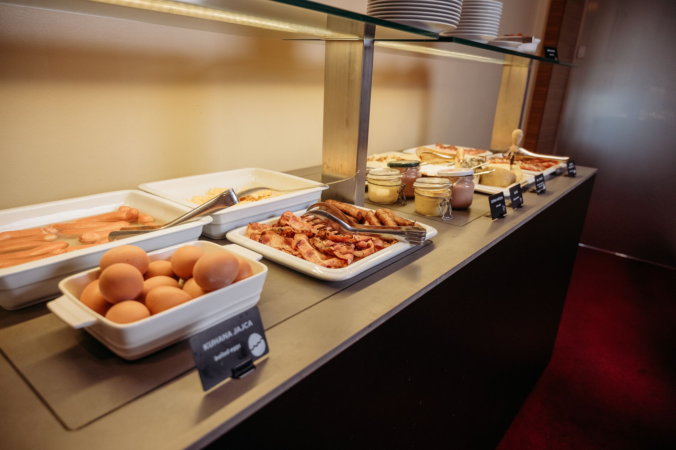 A buffet with various food items including eggs, bacon, and sauces.