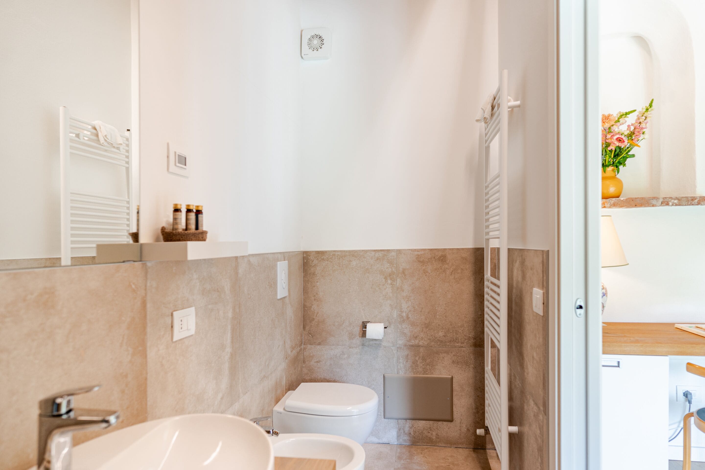A modern bathroom with a white sink, a toilet, and a shower area.