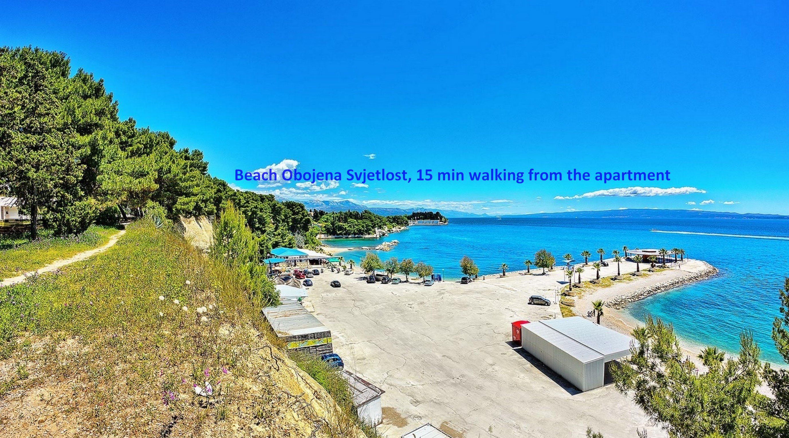 Ein Strand mit freiem Blick auf den Ozean, einem Parkplatz und einem Weg zum Strand.