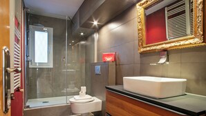 Ein modernes Badezimmer mit einer Duschkabine, einem weißen Waschbecken und einem Holzbadezimmer-Möbel.