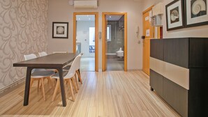Eine moderne Küche mit Holztisch und -stühlen, einem Kühlschrank und einem Wanddesign mit Muster.