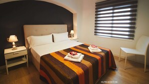 A hotel room with a large bed, two bedside tables with lamps, a chair, and a window with blinds. - Alcam Alio Cine (Barcelona)
