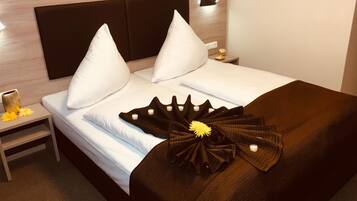 Una cama bien hecha con sábanas blancas y un edredón marrón decorativo.