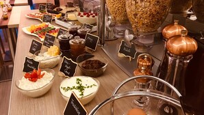A buffet with various food options including dips, fruits, and grains.