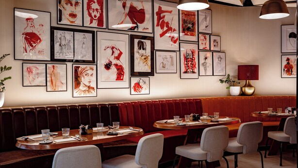 A restaurant with red booths and tables, featuring framed artwork on the walls. - ME Dubai by Meliá (Dubai)