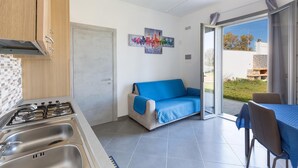 Een moderne keuken met een gasfornuis, een spoelbak en een eethoek met een tafel en stoelen.