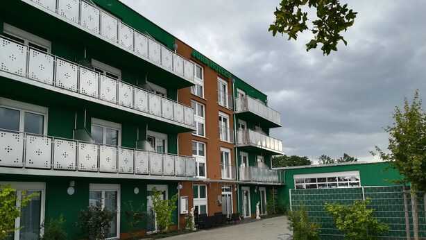 A multi-story hotel with balconies and a paved courtyard. - Jura Hotel (Nuremberg)