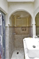 Un bagno con doccia, lavandino e specchio.