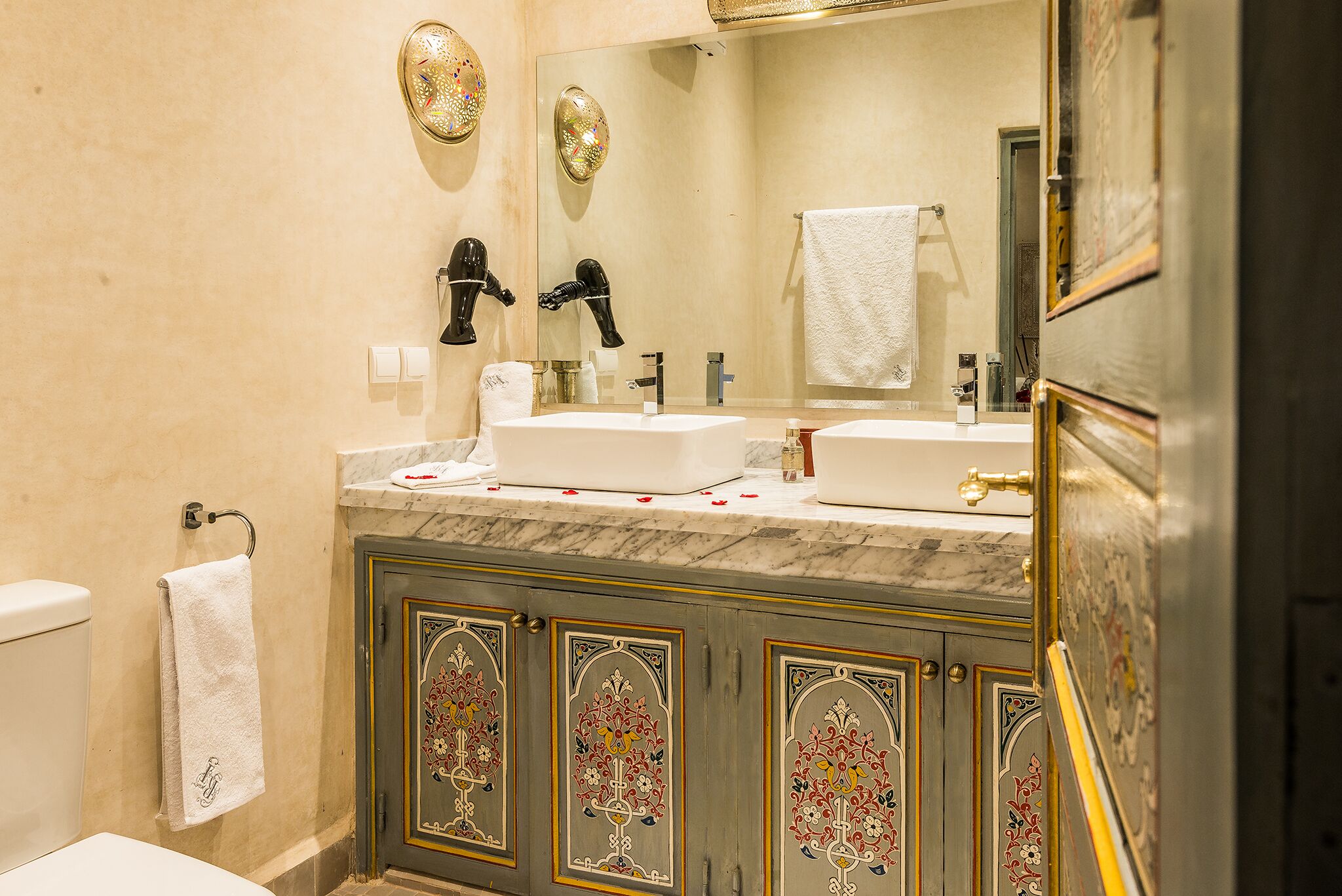 A bathroom with two sinks, a toilet, and a mirror.