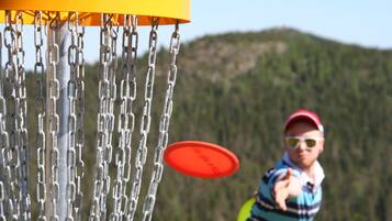 A chain-link fence with a frisbee in motion.