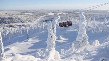 Un paysage enneigé avec une télécabine visible au loin.