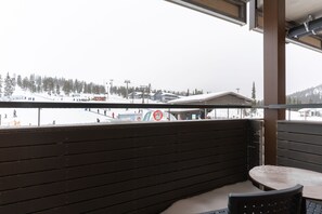 A balcony with a view of a ski resort.
