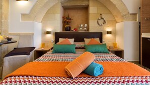 Une chambre d’hôtel avec un lit, une petite table et une chaise. On y trouve une cheminée sur laquelle est posée une guirlande décorative.