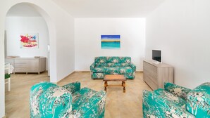 A living room with a sofa, a coffee table, and a TV stand. - Villa Melograno (Porto Cesareo)