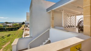 Un bâtiment moderne doté d’un escalier menant à un balcon qui offre une vue sur un paysage verdoyant.