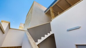 Un design architectural moderne, avec un escalier menant à un niveau supérieur, une fenêtre bien visible et un luminaire.