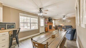 A spacious kitchen with a wooden table, chairs, and a fireplace. - Creek Lodge  - LaGrange's Best Kept Secret (LaGrange)