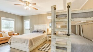 A bedroom with a bed, a chest of drawers, a ceiling fan, and a window. - Creek Lodge  - LaGrange's Best Kept Secret (LaGrange)
