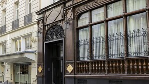 A building facade with ornate iron railings, a glass entrance, and a sign indicating a hotel. - Maison Albar Hotels Le Vendome (Paris)