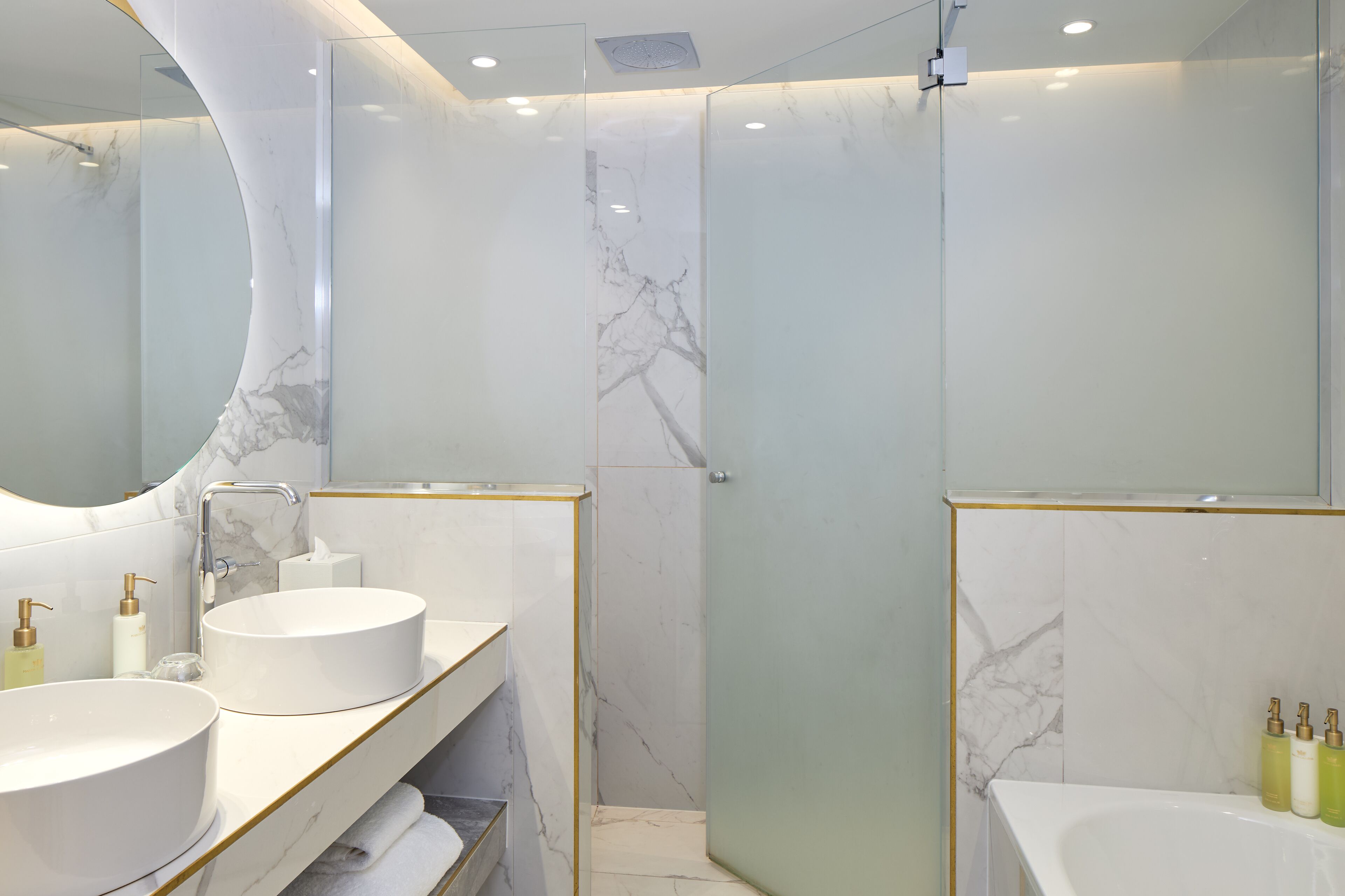 A modern bathroom with two sinks, a large mirror, and a glass shower enclosure.
