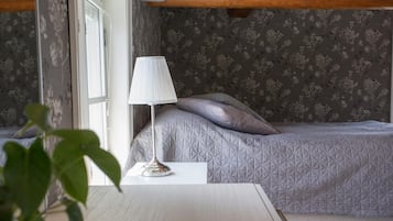 Une chambre à coucher avec un lit, une lampe de chevet et une fenêtre.