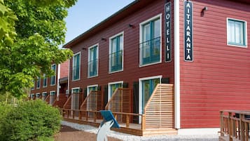 Punainen rakennus, jossa on useita ikkunoita ja parvekkeita, ja sen yläpuolella on kyltti, jossa lukee: ”AITTANTA HOTEL”.