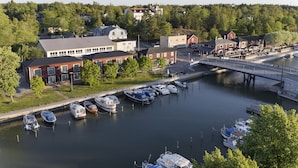 En lystbådehavn med fortøjede både, en bro og bygninger i baggrunden.