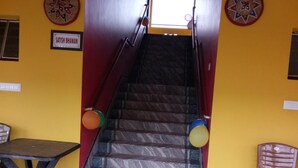 A staircase leading to a landing with a red mat at the bottom. - Asian Grand Villa (Bolpur)