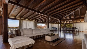 A spacious living area with a large sofa, a coffee table, and a dining table with chairs. - Villa Flo (Sannicola)