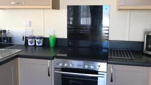 Una cocina compacta con estufa, horno y microondas.