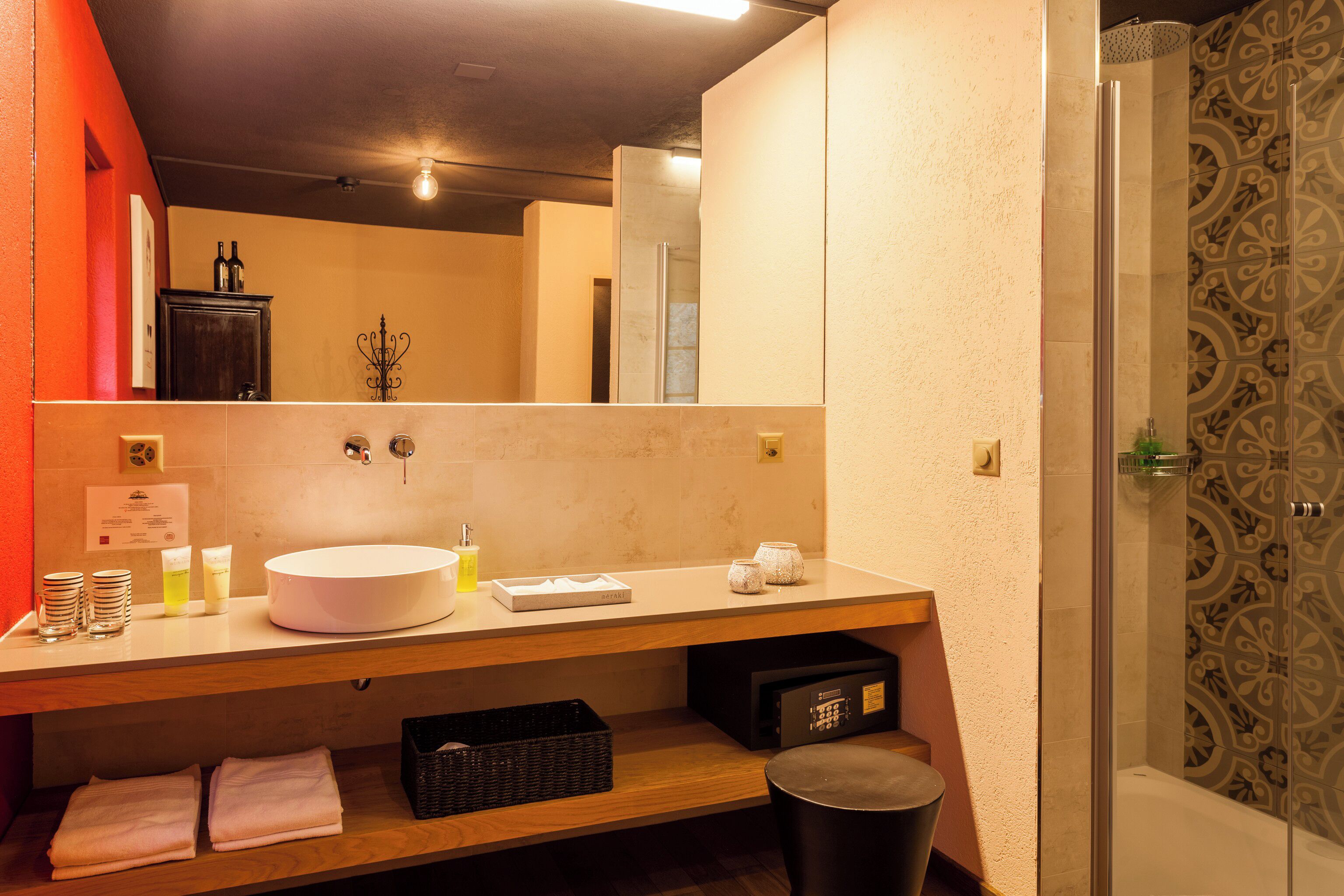 Une salle de bain avec un grand miroir, un lavabo et une douche.