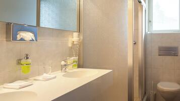 A bathroom with two sinks, a mirror, a towel rack, and a toilet.