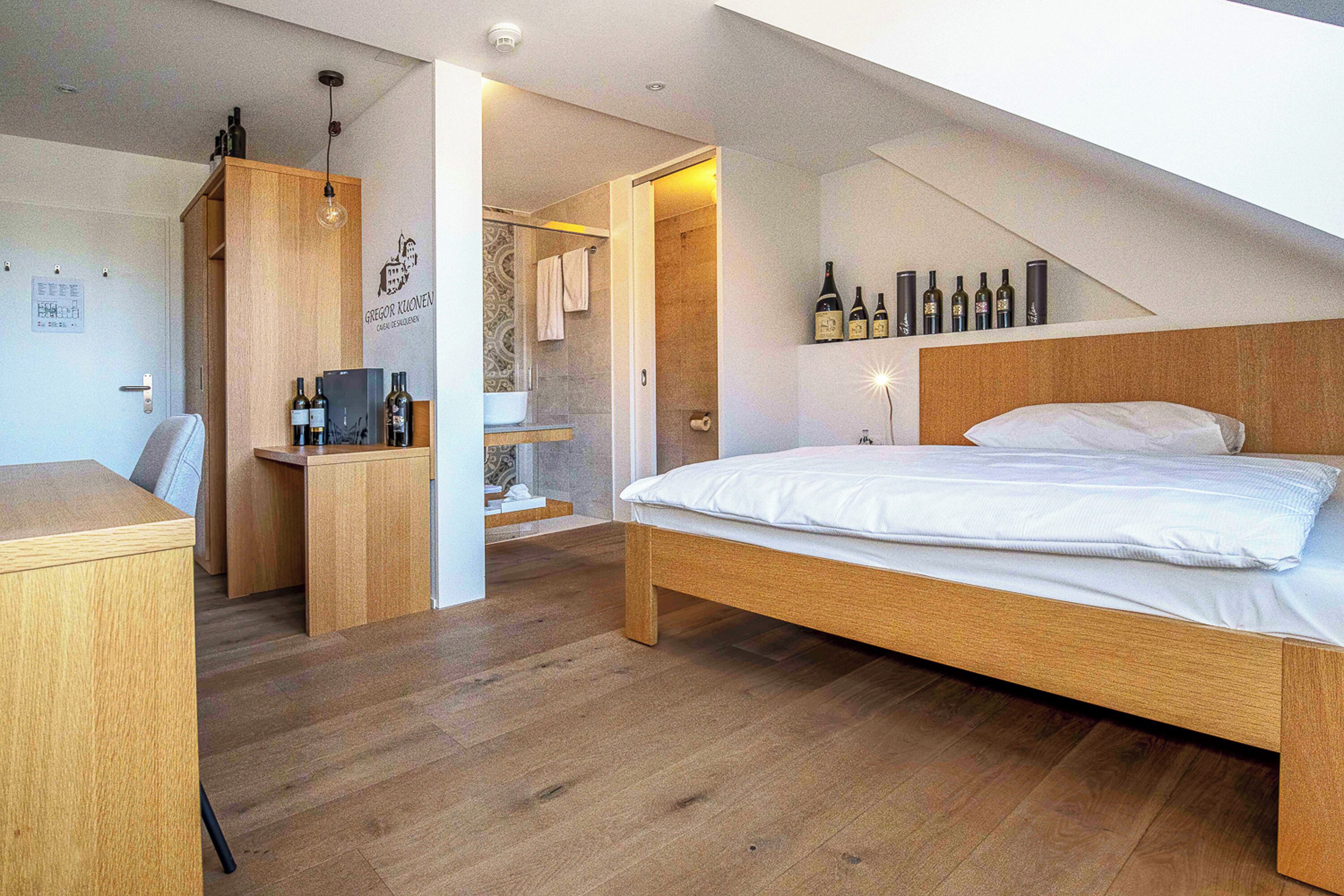 A modern bedroom with a wooden bed, a desk, and a shower area.