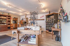 A well-organized wine shop with wooden shelves, a central display table, and a variety of wine bottles. - Hirschen Erlinsbach Swiss Quality (Erlinsbach)