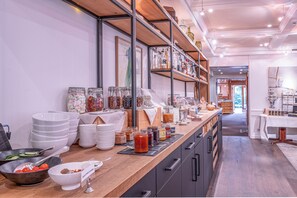 A buffet setup with various food items and condiments on a wooden counter, surrounded by shelves with kitchenware and decorative items. - Hirschen Erlinsbach Swiss Quality (Erlinsbach)