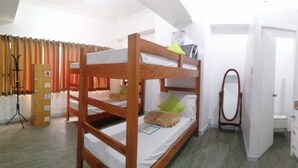 A compact room with bunk beds, a small kitchenette, and a door leading to another room. - V - Rooms Hostel - Adults Only (Makati)