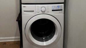 Un appareil combiné lave-linge et sèche-linge à chargement frontal, doté de panneaux de commande, d’un écran numérique et d’un lave-linge à chargement frontal.