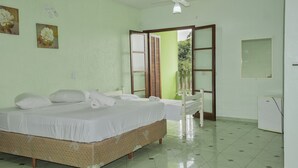 A room with a bed, a small table, a chair, a ceiling fan, and a door leading outside. - Estância Solazer (Santa Isabel)